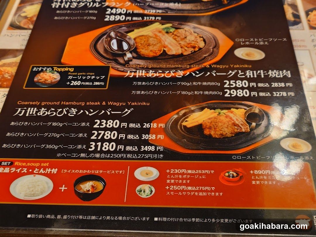 A close-up of a Japanese restaurant menu featuring Arabiki beef burgers and wagyu yakiku dishes, with prices in yen.