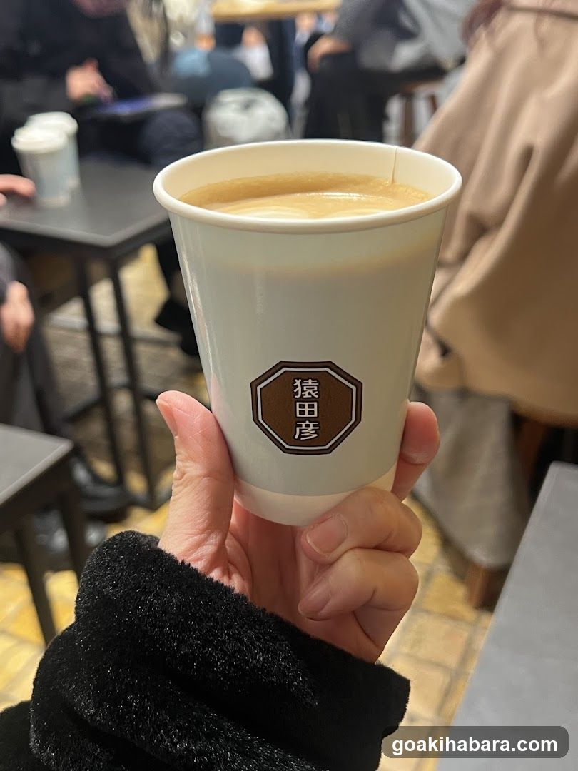 Hand holding a coffee cup with Japanese characters