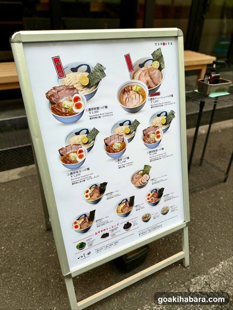 A standing menu board displaying various ramen dishes with prices and descriptions in Japanese and English.