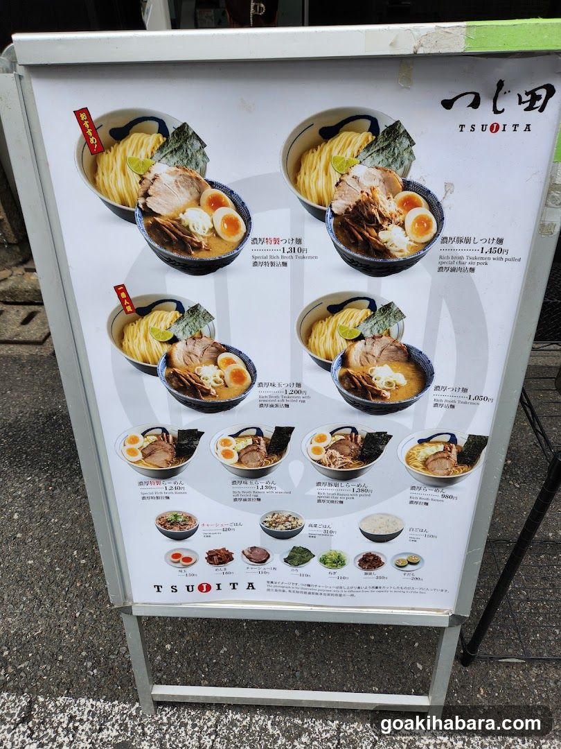 A menu board displaying various ramen dishes with prices and descriptions in Japanese and English.