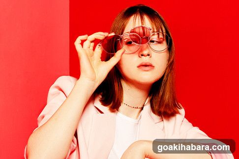 Woman with glasses against red background