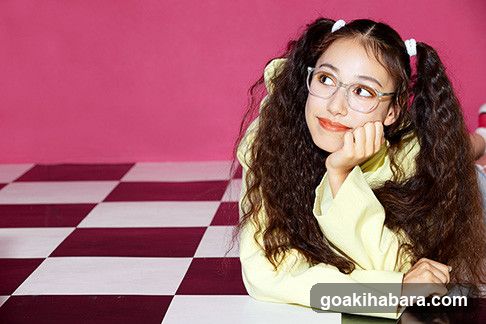 Girl with pigtails resting chin on hand