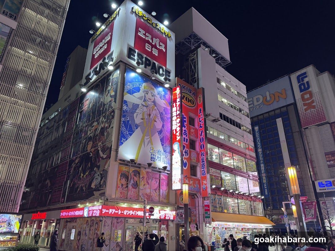 Night street scene with illuminated buildings and crowds
