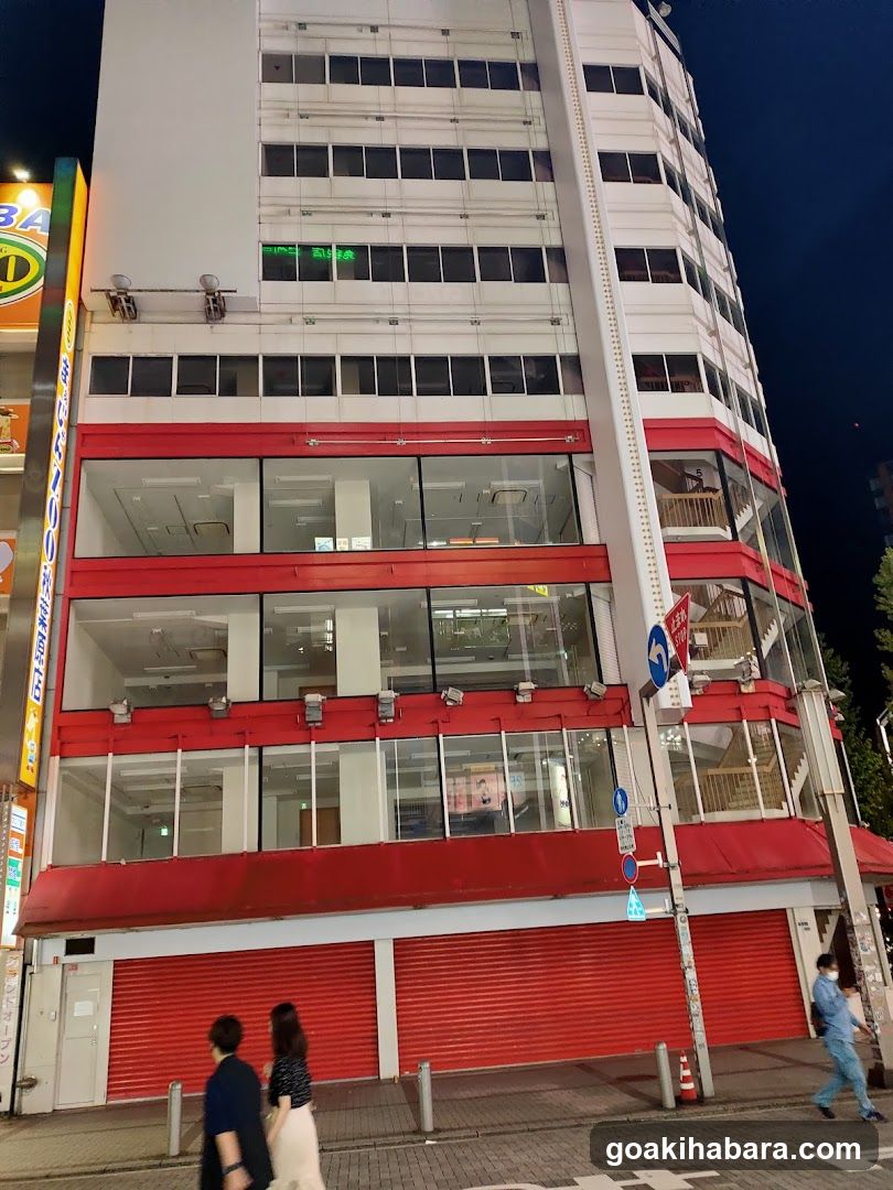 Night street view of a building with red storefronts