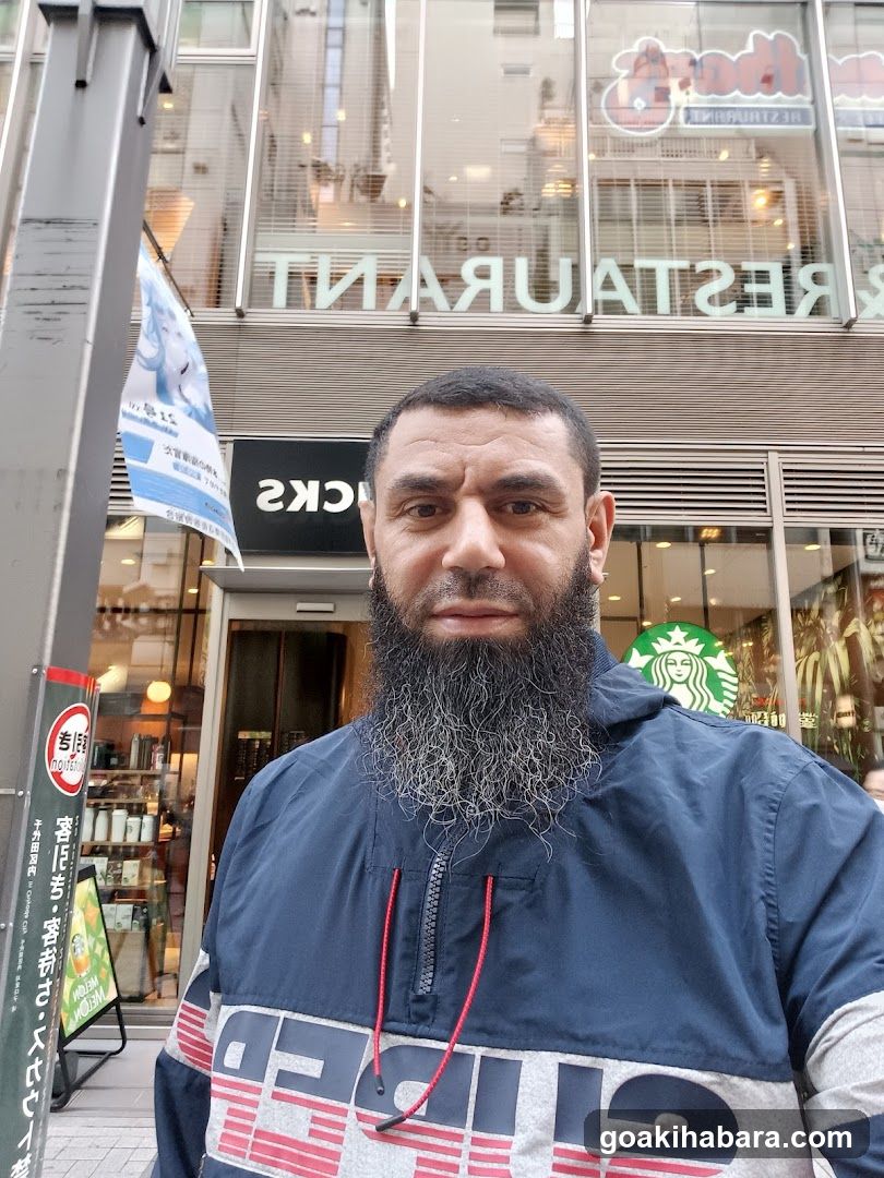 Man with beard in front of storefronts