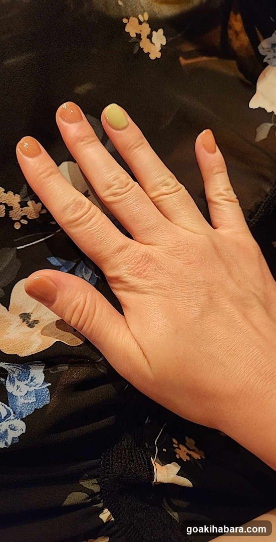 Hand with Nail Polish on Floral Fabric