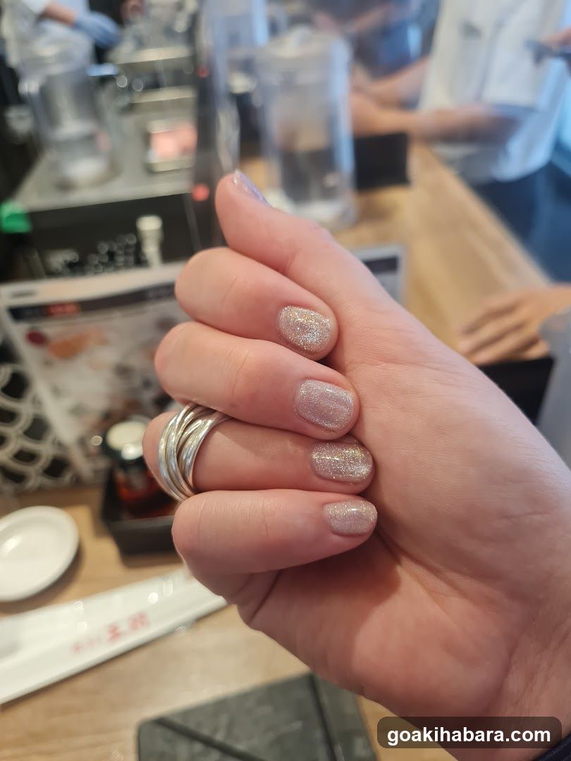 Hand with glitter nail polish in a shop interior