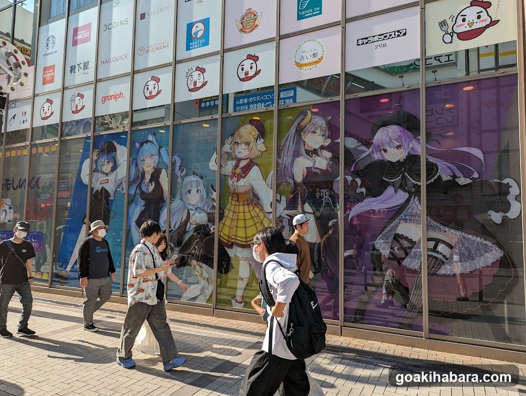 Anime-themed storefront with large character posters and multiple brand signs above the windows.