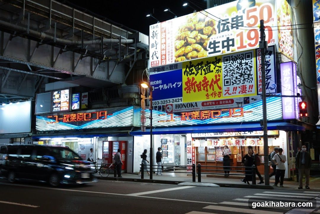 Night street scene with illuminated signs and storefronts
