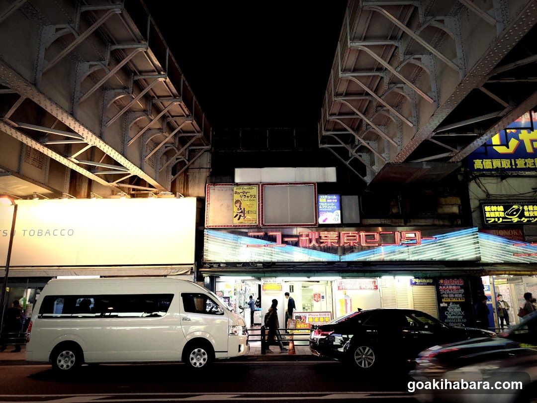 Night street scene with storefronts and vehicles