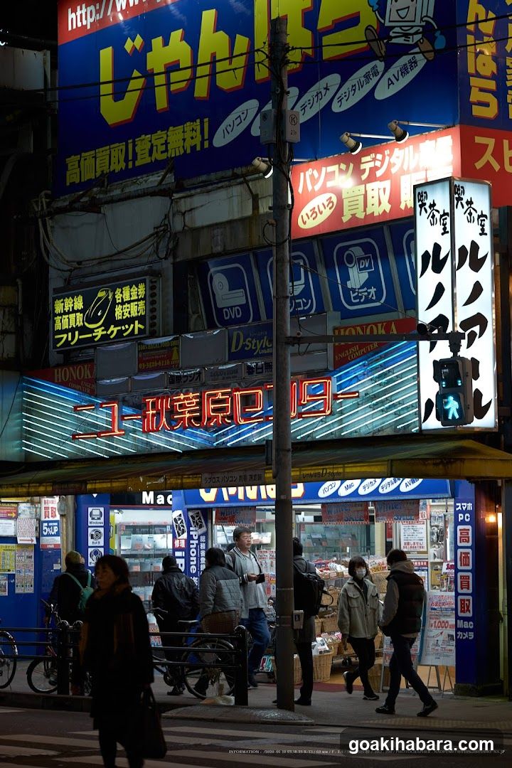 Nighttime Street Scene with Neon Signs and Pedestrians