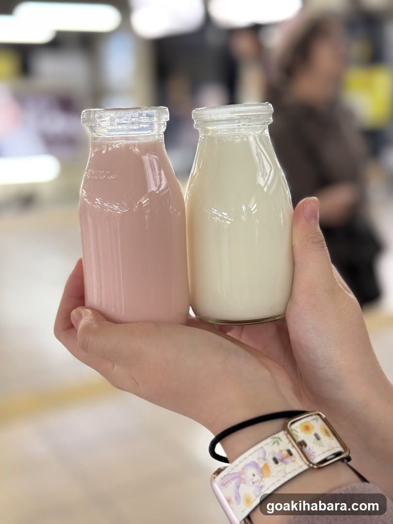 Hand holding two glass bottles of milk