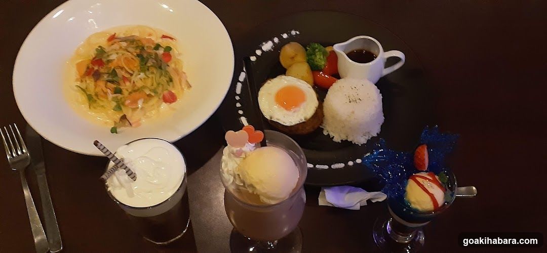 Dining Table Spread with Pasta, Rice Dish, and Desserts