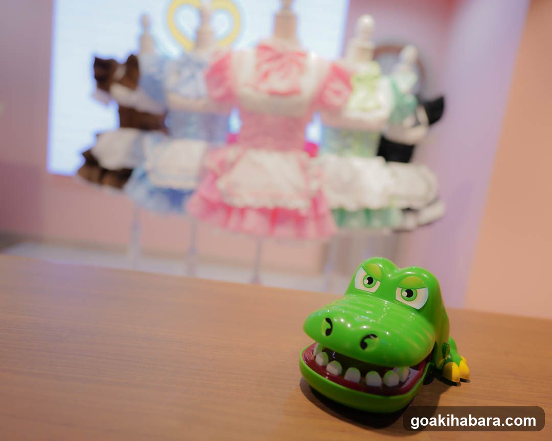 Green Alligator Toy with Miniature Dresses in Background