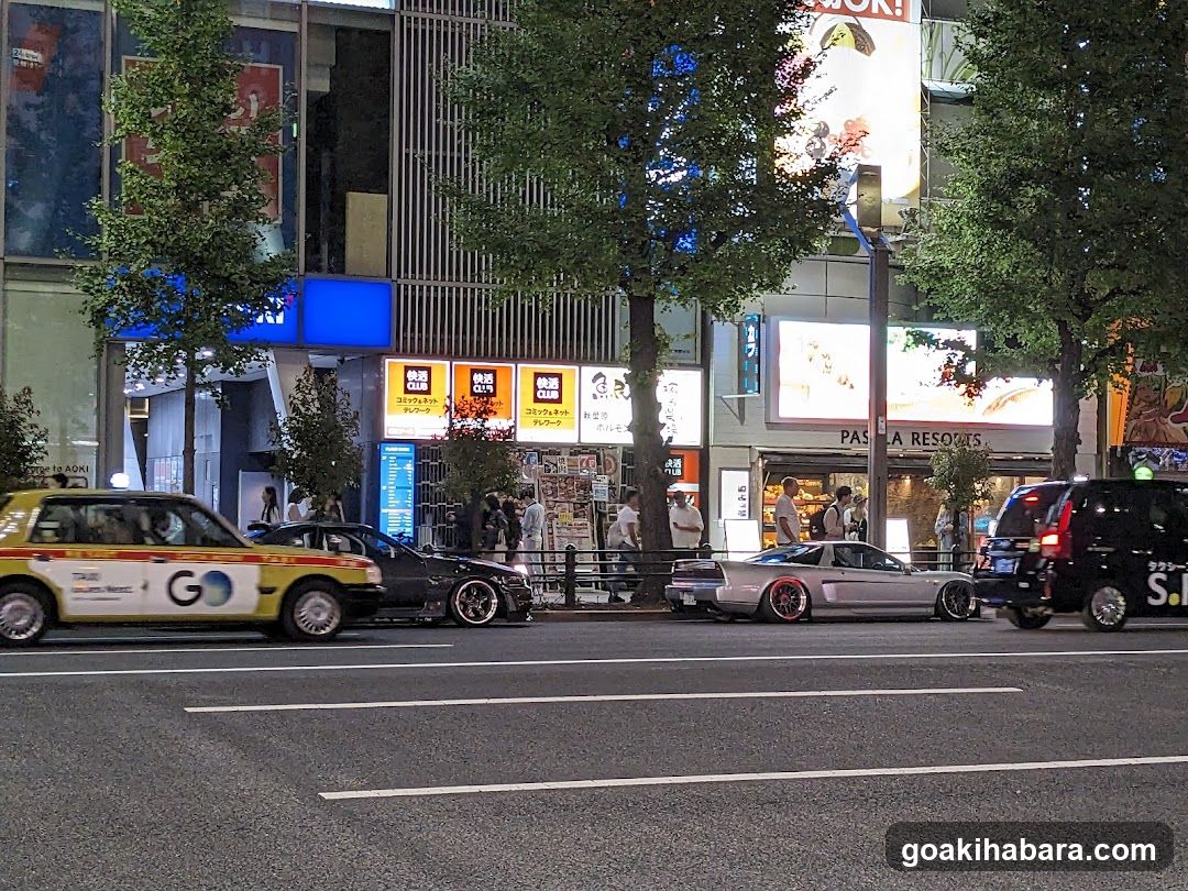 Night street scene with cars and shops
