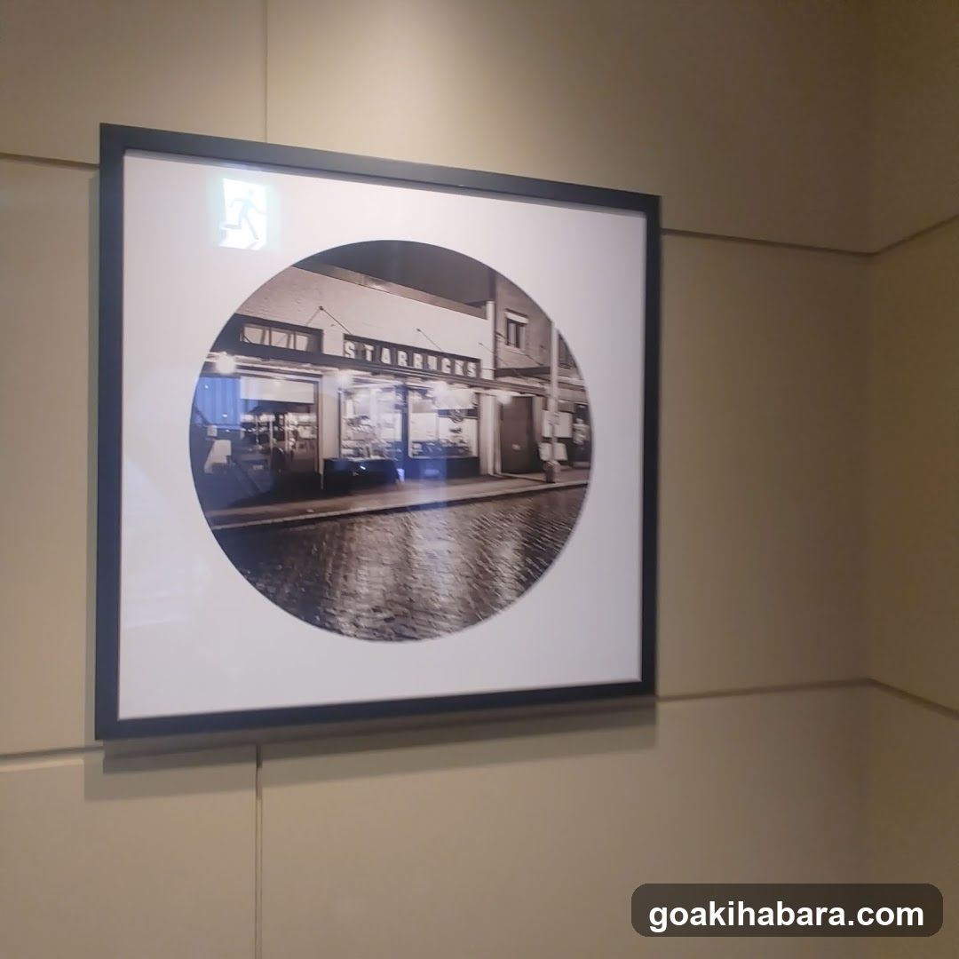 Black and white photo of a Starbucks shop front with visible signage on the building facade, cobblestone street in foreground.