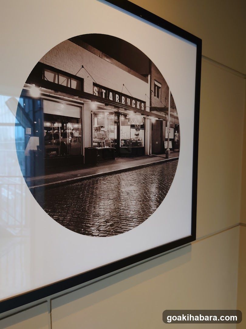 A black and white photo of a Starbucks shop front with visible signage on the building facade, cobblestone street in foreground.