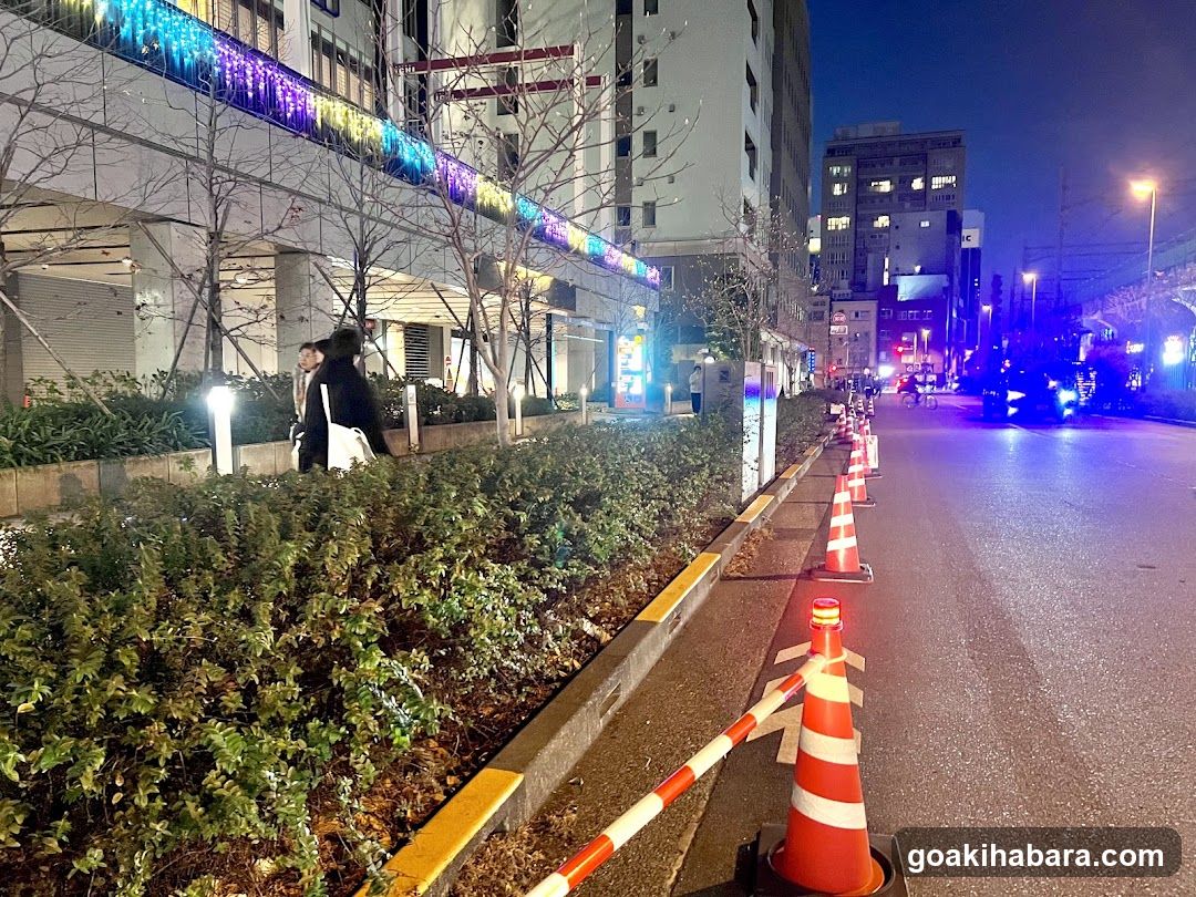 Night street scene with traffic cones and festive lights