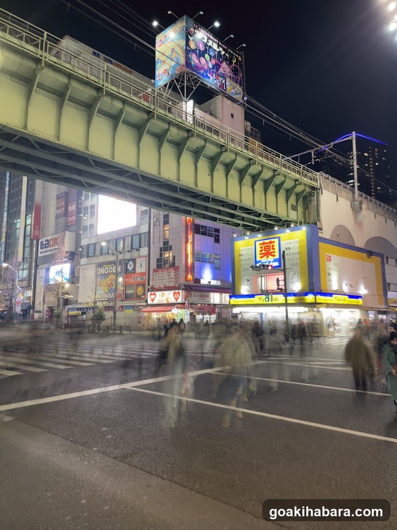 Night street scene with pedestrian crossing and illuminated storefronts
