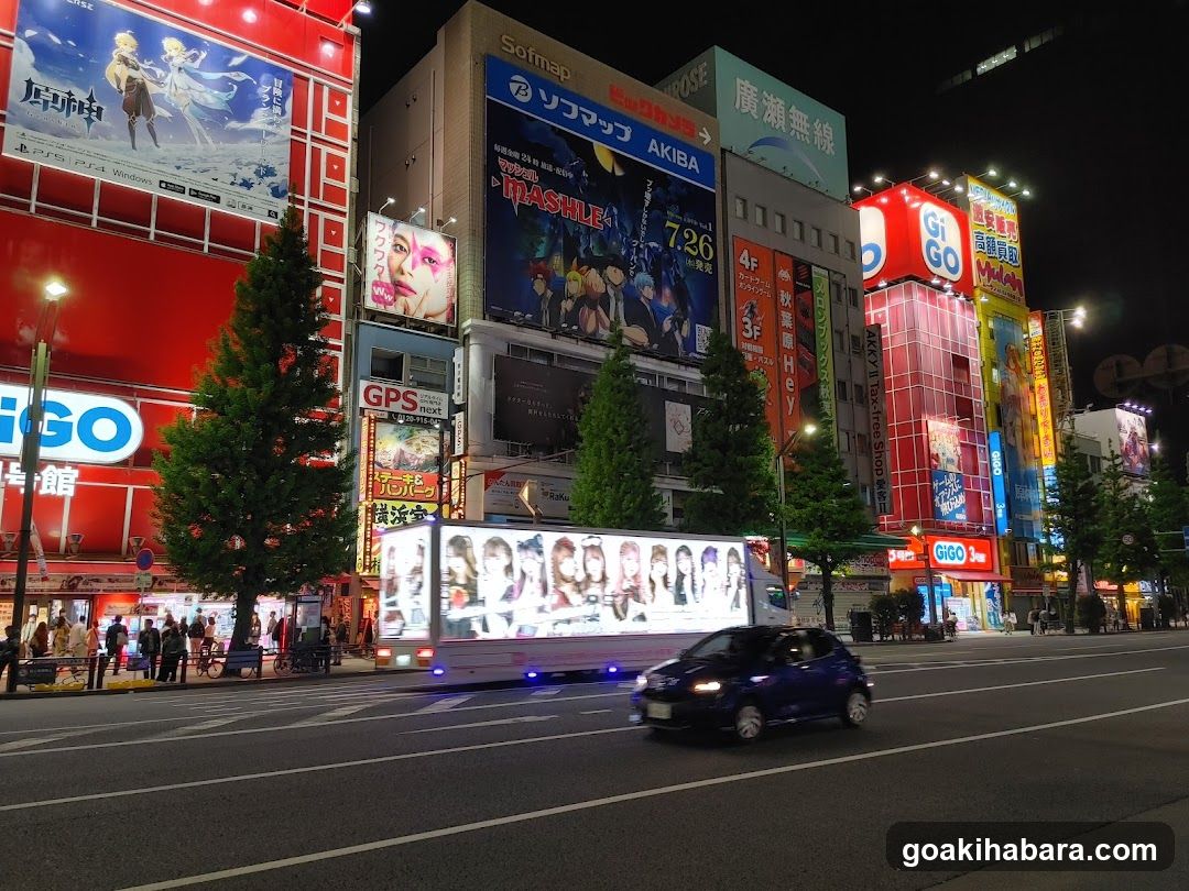 Night street scene with illuminated billboards and vehicles