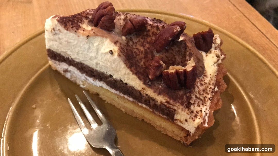 Slice of layered dessert tart with pecans