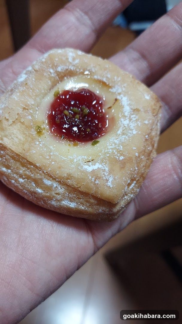 Hand holding a pastry with jam filling