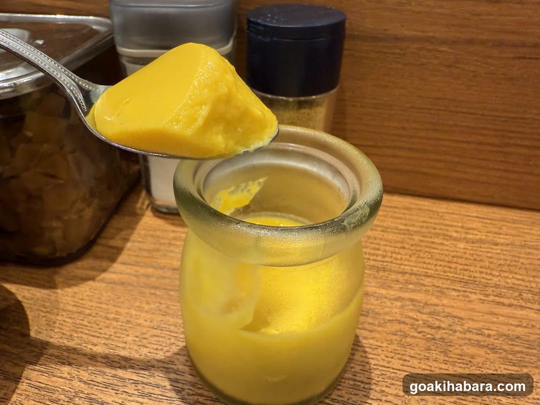 Bowl of yellow dessert with spoonful on top