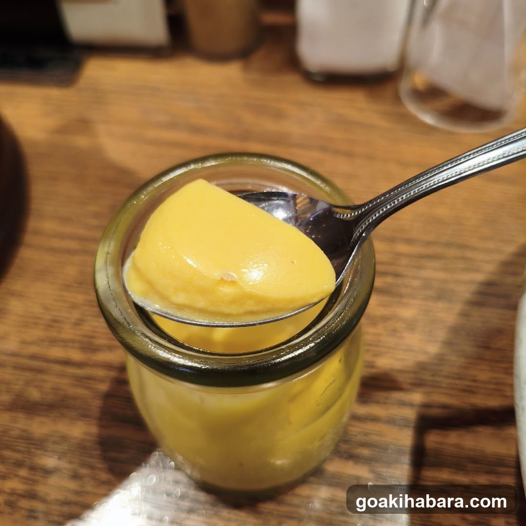 Spoonful of yellow dessert in glass jar