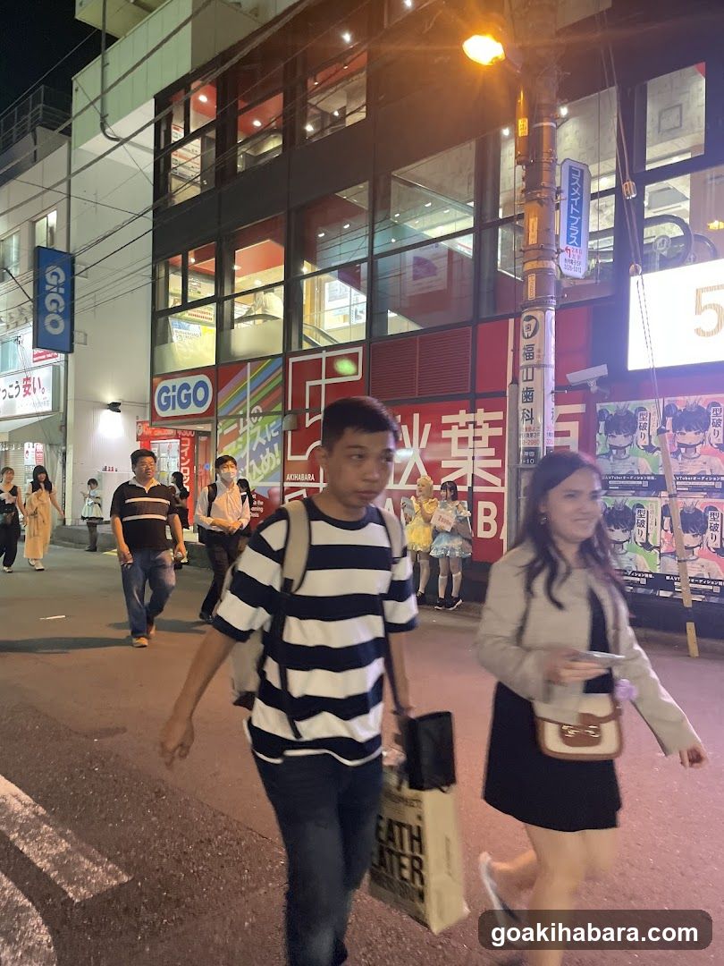 Night street scene with pedestrians and storefronts
