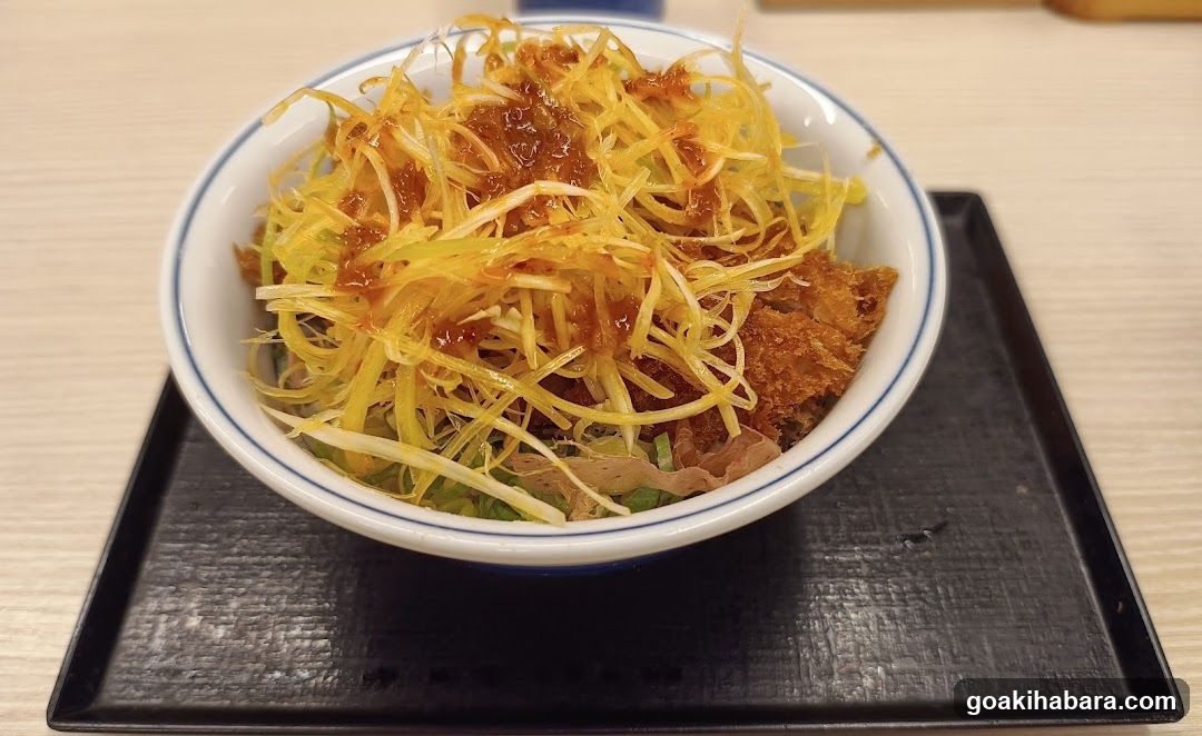 Bowl of shredded food with sauce
