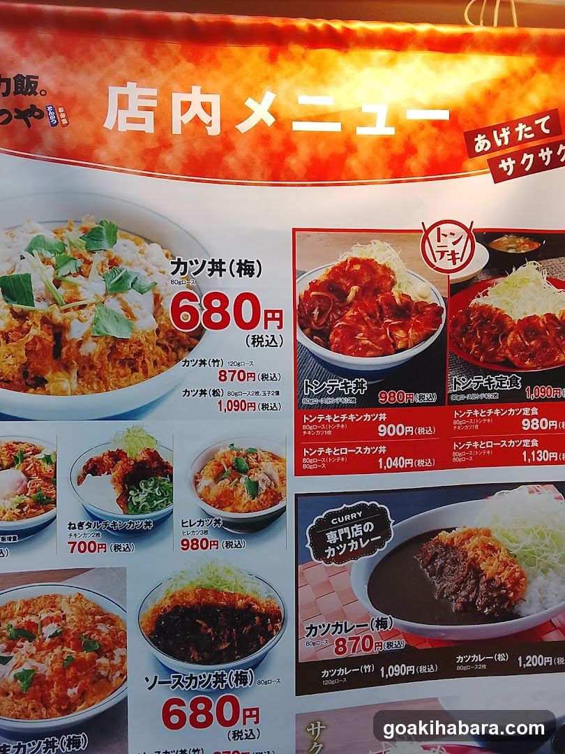 A Japanese in-store menu board featuring various dishes with prices, including Katsu Don, Tonkotsu Ramen, and Curry Rice.