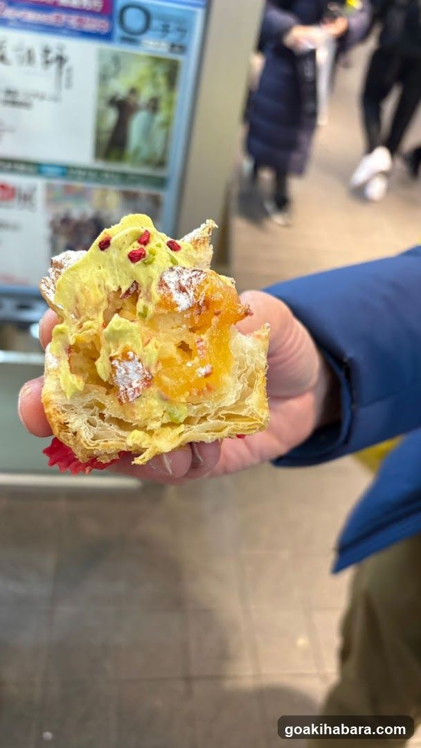 Hand holding a pastry with fruit filling