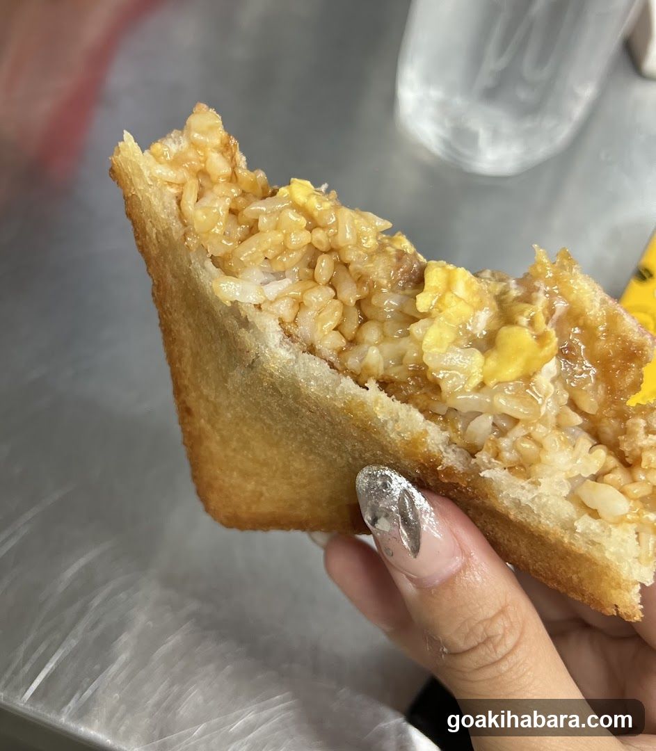 Hand holding a fried rice sandwich