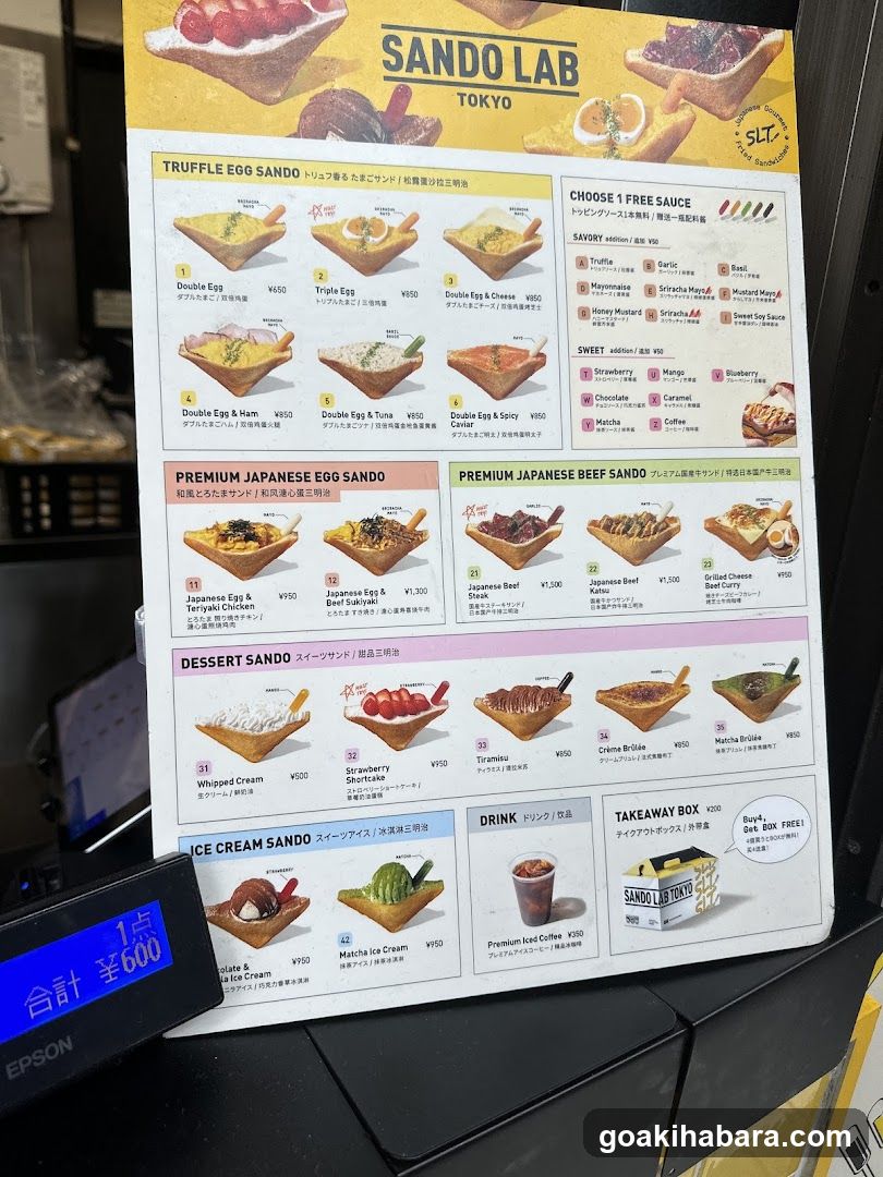 A printed menu board from Sando Lab in Tokyo, featuring various egg sando options with prices and descriptions.
