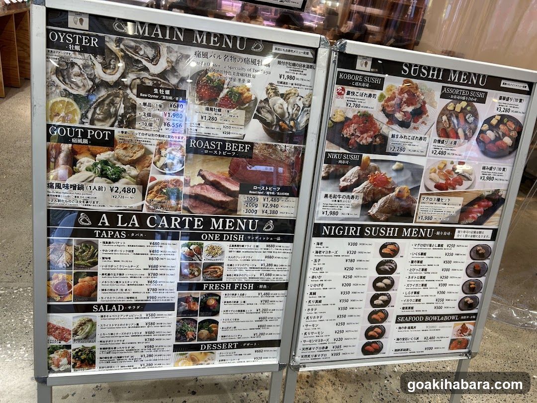A large, freestanding menu board displaying various food categories including Oyster, Gout Pot, Roast Beef, Sushi (Roboro, Nigiri), Tapas, One Dish, Fresh Fish, Salad, Dessert, and Seafood Bowl.