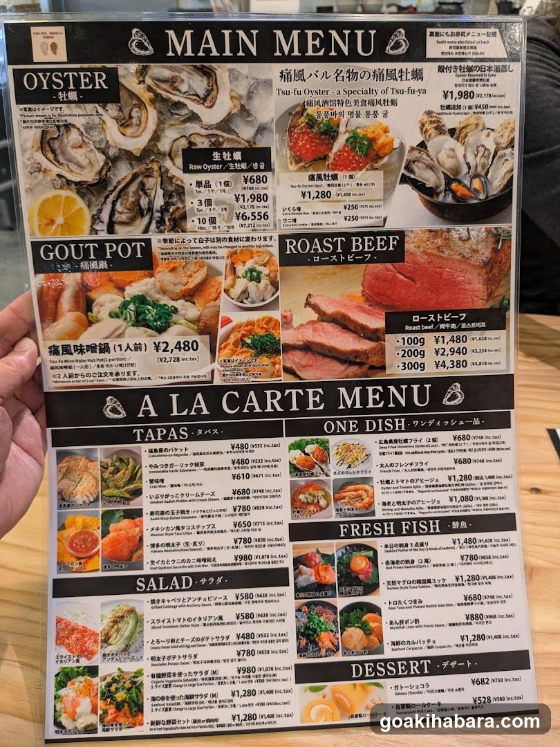 A close-up of a printed menu board held by a hand, featuring sections like Oyster, Gout Pot, Roast Beef, Tapas, One Dish, Fresh Fish, Salad, and Dessert with prices in Yen.