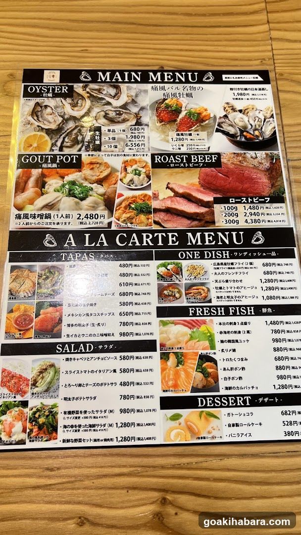A printed Japanese restaurant menu displayed on a wooden table, featuring sections for Oyster, Gout Pot, Roast Beef, Tapas, One Dish, Fresh Fish, Salad, and Dessert with prices in Yen.