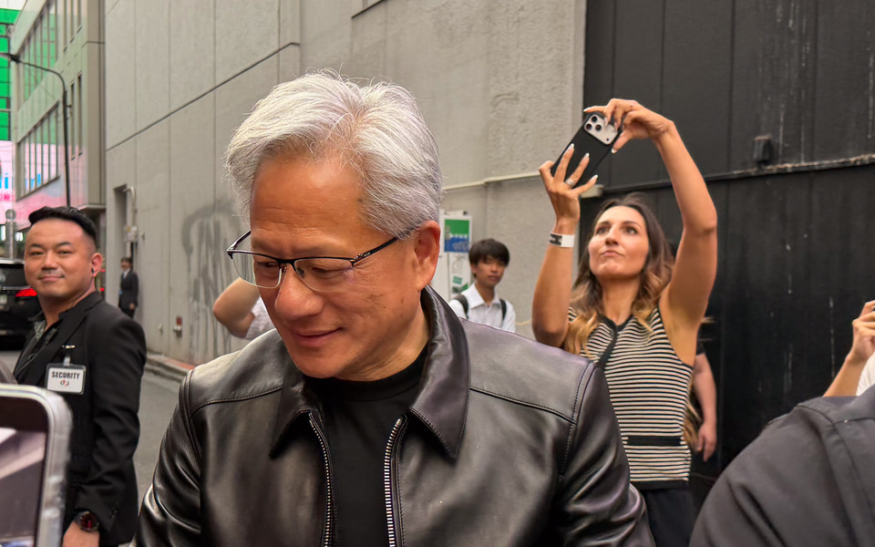 Jensen Huang signing autographs for fans gathered at the Akihabara event